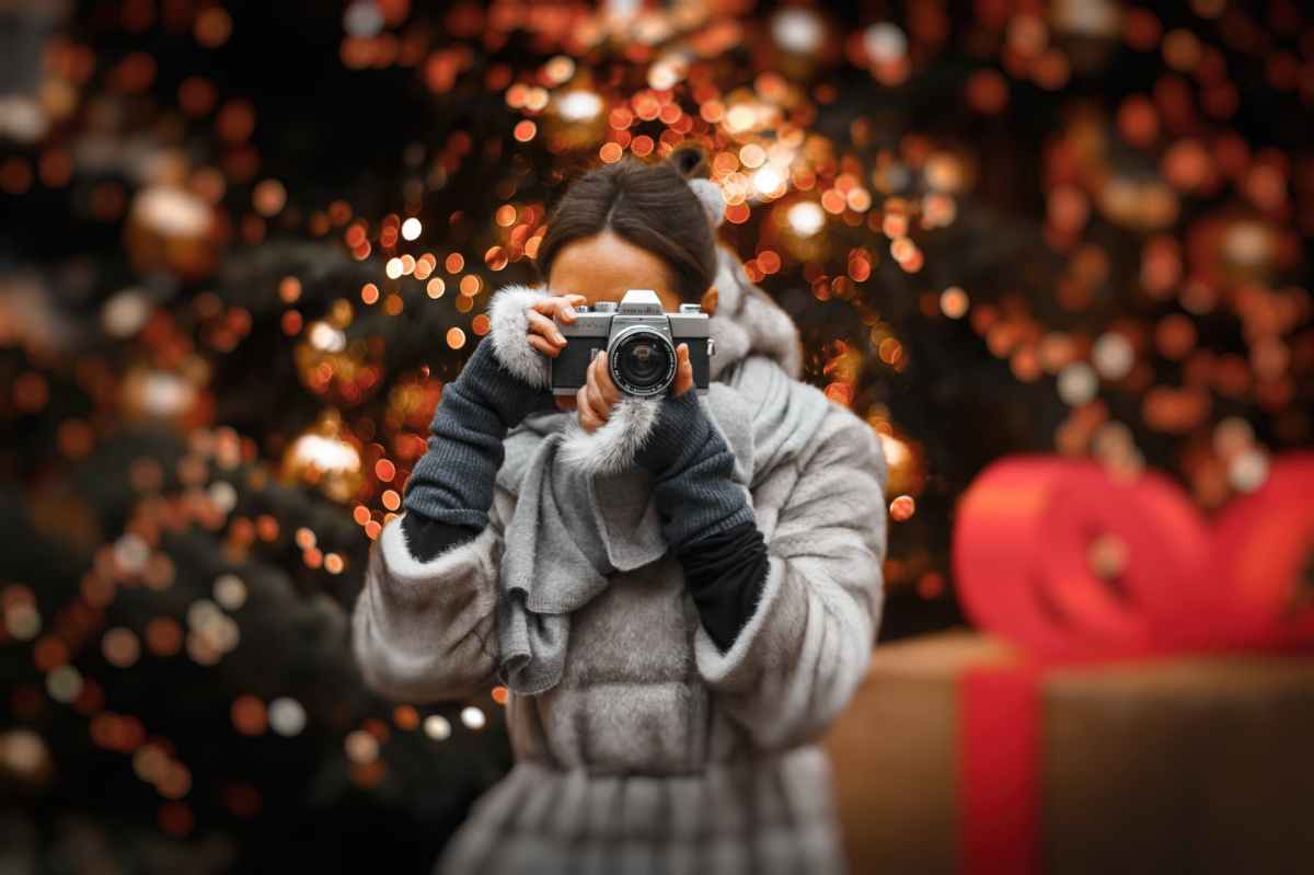 A woman looking at the photographer through a camera